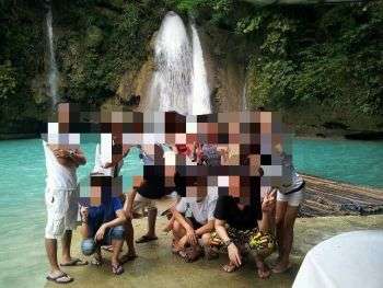 青い池のまえで複数人が立って写真を撮られている